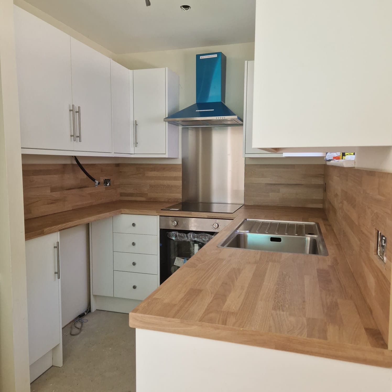 Fitted kitchen with white units and solid oak worktop by RPG Carpentry in South East Cornwall